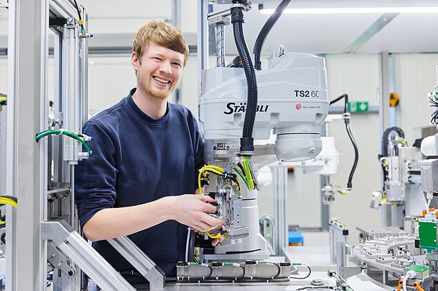 apprentice working on a robot in assembly