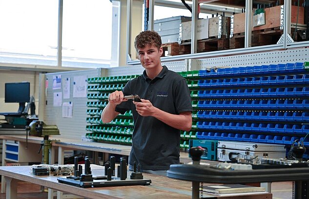 apprentice measuring a manufacturing part