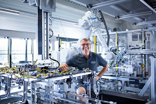 Assembly Technician standing in a machine, smiling to the camera