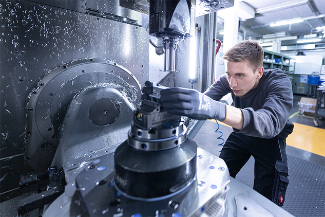 Machinist Apprentice removing a CNC part from the machine